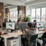 Vue d'ensemble d'une agence de développement web moderne dans les Hauts-de-France avec une équipe collaborative autour de postes de travail