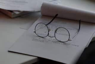 black framed eyeglasses on top of white printing paper