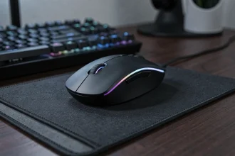 Souris gaming sans fil sur tapis de souris avec clavier mécanique en arrière-plan dans un setup gaming sombre